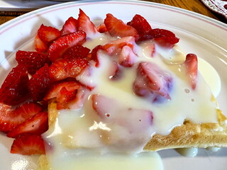 Strawberries with creme brulee Lying on waffles Delicious appetizing dessert Camera shoots from above while swimming slowly