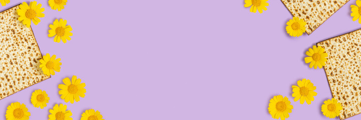 Yellow daisy and matzah for Jewish holiday Pesach (Passover) on purple background with copy space. Holiday banner.