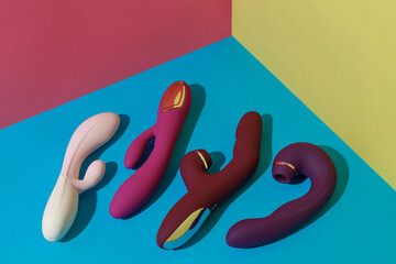 Many dildo vibrators for satisfaction on colored background. Sex toy for adult. Sex shop concept