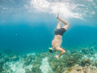man snorkeling in crystal clear tropical sea