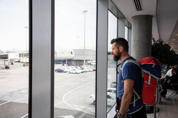 handsome man with backpack waiting in airport