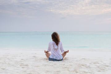 Fototapeta na wymiar woman in meditation posture by the sea