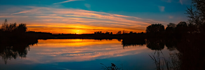 High resolution stitched sunset panorama with reflections near Wallersdorf, Bavaria, Germany