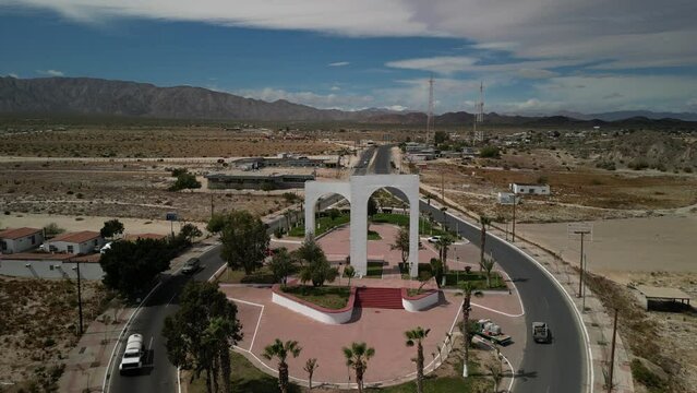 Aerial push in and reveal past double white arches in center of town of San Felipe Baja California Mexico