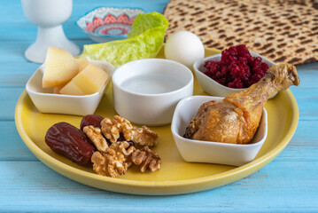 Symbolic meal for Passover (Pesach) Seder Plate. Walnuts and date fruits, lamb bone on the background of traditional meal for Pesach. 
