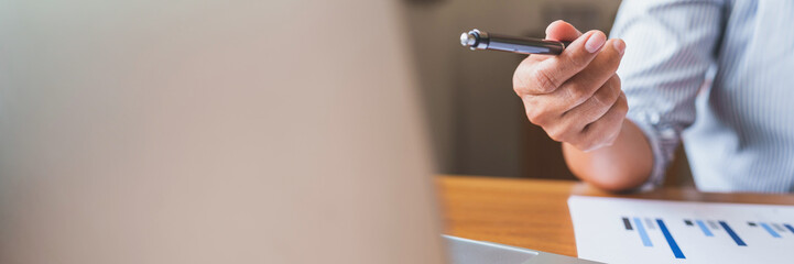 Hand holding pen pointing at laptop, online working corporate.. © mojo_cp