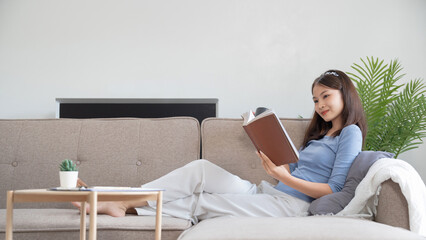 Young asian woman reading a book at home, girl hold book Education school university college concept.concept.