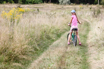 A Happy child cycling in the park concept in nature