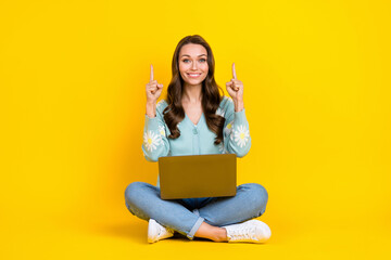 Full length photo of pretty shiny lady dressed teal cardigan chatting gadget pointing up empty space isolated yellow color background