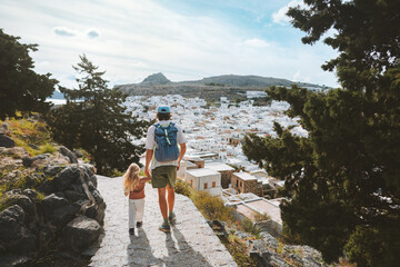 Family travel in Greece father and child sightseeing Rhodes island Lindos city white houses aerial...