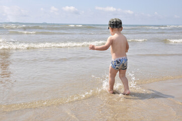 criança brincando no mar 