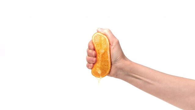 Male hand compress orange half squeeze juice drop fresh summer beverage closeup slowmo isolated