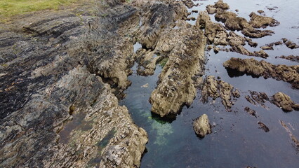 Rocky shore. Big rocks. Seascape. Brown rock on water