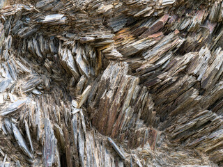 Stone layers close-up, stone background. Compressed rock layers formation in various colors and thicknesses. Nature and Geological science concept. The close-up relief of the rocks layers