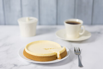 New York cheesecake or classic vanilla cheesecake banner. Delicious cheesecake with a mug of hot tea on a white stone background. Selective focus