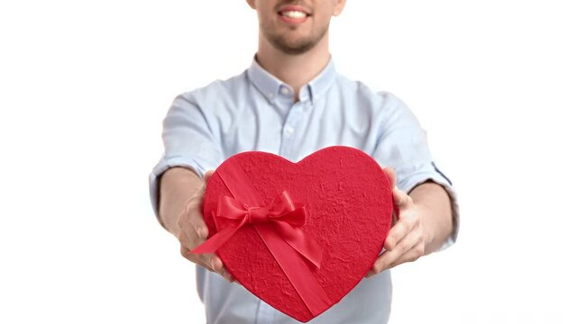 Unrecognizable smiling man giving red heart gift box Valentine's Day birthday celebrate isolated