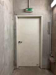 1 door in a basement with concrete walls and breeze blocks.