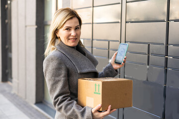 Beautiful woman picking up a package from a smart electronic steel parcel locker box, automatic mailboxes. Paczkomat delivery service, collection machine © Angelov