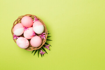 Pink Easter eggs with decor on color background, top view