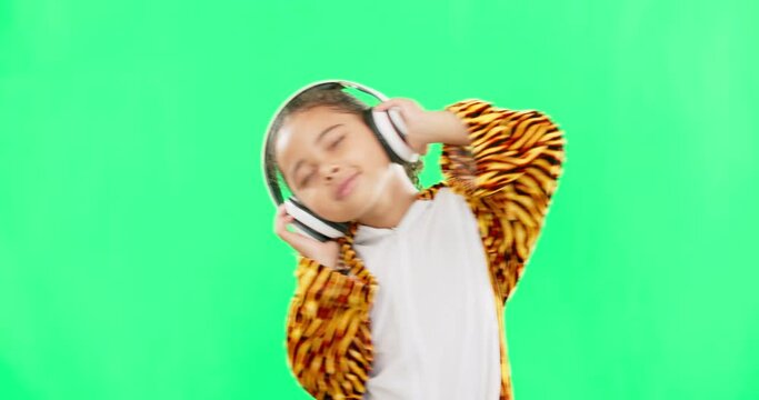 Kids, music and dance with a girl on a green screen background in studio streaming audio while having fun. Children, energy and freedom with a little female child dancing while listening to the radio