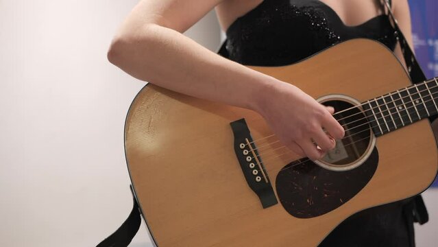 Female singer playing guitar backstage