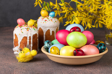 Spring still life of Easter cakes decorated colorful eggs on brown background