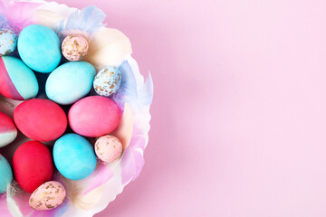 Fototapeta na wymiar Painted Easter eggs in crimson and blue on a pink background with a place for text. Happy Easter concept. Greeting card, copy space