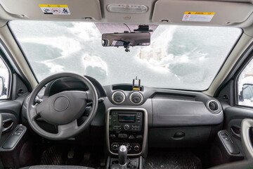 car windshield under a layer of snow, winter frozen car window