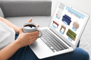 Woman with laptop buying online new furniture at home - obrazy, fototapety, plakaty