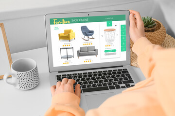 Woman with laptop buying online new furniture at home