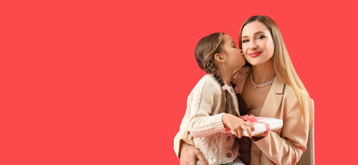 Cute little girl greeting her mother with gift on red background with space for text