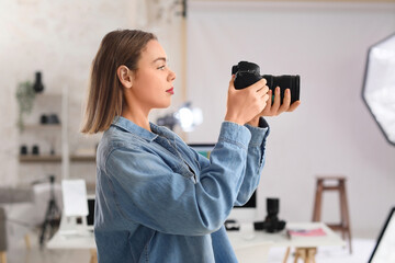 Female photographer with professional camera in studio