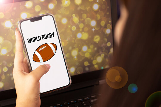 woman holding cell phone watching rugby world cup - Powered by Adobe