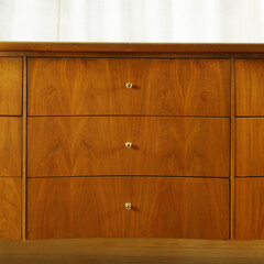 Mid-century modern wooden dresser. Vintage furniture close-up detail of drawers.