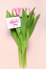 Greeting card with text HAPPY MOTHER'S DAY and beautiful tulip flowers on pink background