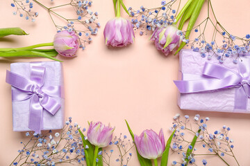 Frame made of beautiful tulip flowers and gift boxes on pink background