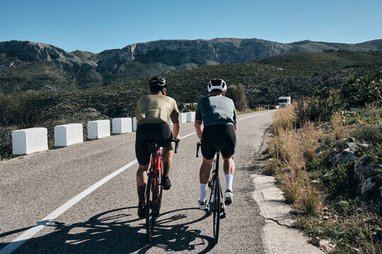 Two cyclists training on mountain pass.Cycling in the spanish mountains.Cyclists in helmets and cycling wear.Sport motivation.Cycling professional group ride.Beautiful view.Xàbia, Alicante, Spain