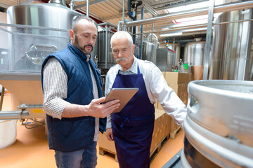 men with tablet at a beer brewery