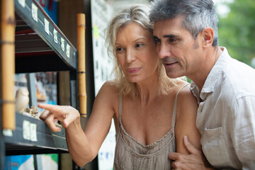 senior tourist couple visiting flea market on holiday