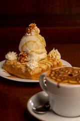 Lemon cheesecake and cup of coffee made by professional barista on wooden background
