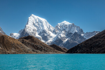 Fototapeta na wymiar Cholatse (6440m) and Taboche (6495m): surreal view from Gokyo lake during our acclimatization day after crossing Renjo-La pass