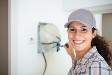 a beautiful electrician inspecting fuseboard