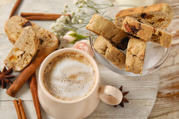 Board with cup of coffee, delicious biscotti cookies, cinnamon and anise on white wooden background