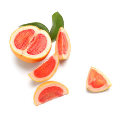 Pieces of ripe grapefruit and plant leaves on white background