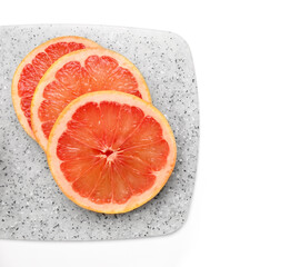 Board with slices of ripe grapefruit on white background