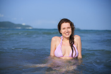 Portrait of happy positive girl, young woman swimming in sea or ocean, enjoying summer vacation, smile, laugh, have fun in water 