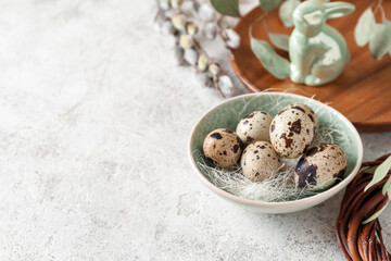 Bowl with Easter quail eggs on white grunge background