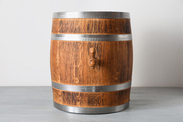 Wooden barrel on table near light wall