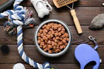 Fototapeta Composition with bowl of wet food and pet care accessories on wooden background obraz