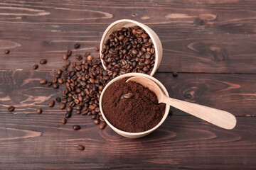 Bowls of coffee powder and beans on dark wooden background